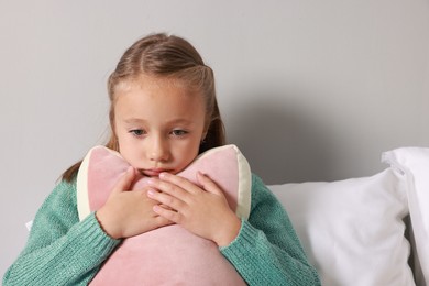 Autism concept. Lonely little girl with pillow at home