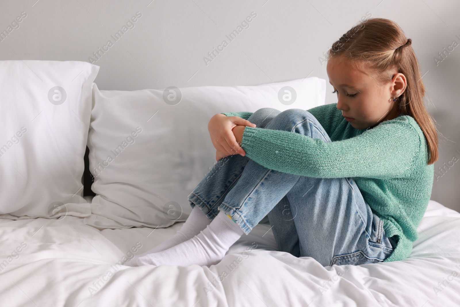 Photo of Autism concept. Lonely little girl on bed at home