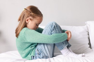 Photo of Autism concept. Lonely little girl on bed at home