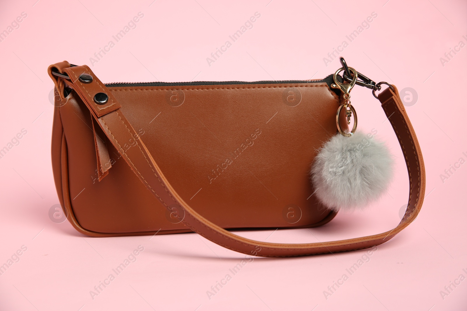 Photo of Brown bag with grey faux fur keychain on pink background