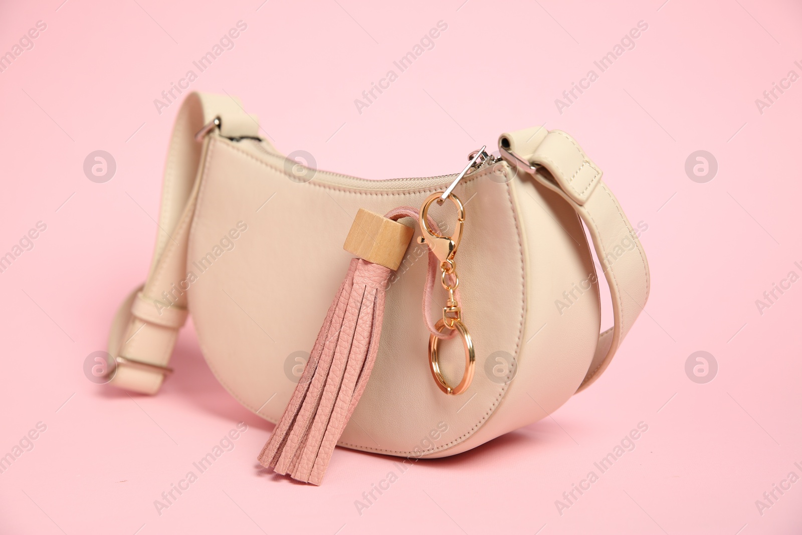 Photo of Bag with leather keychain on pink background, closeup