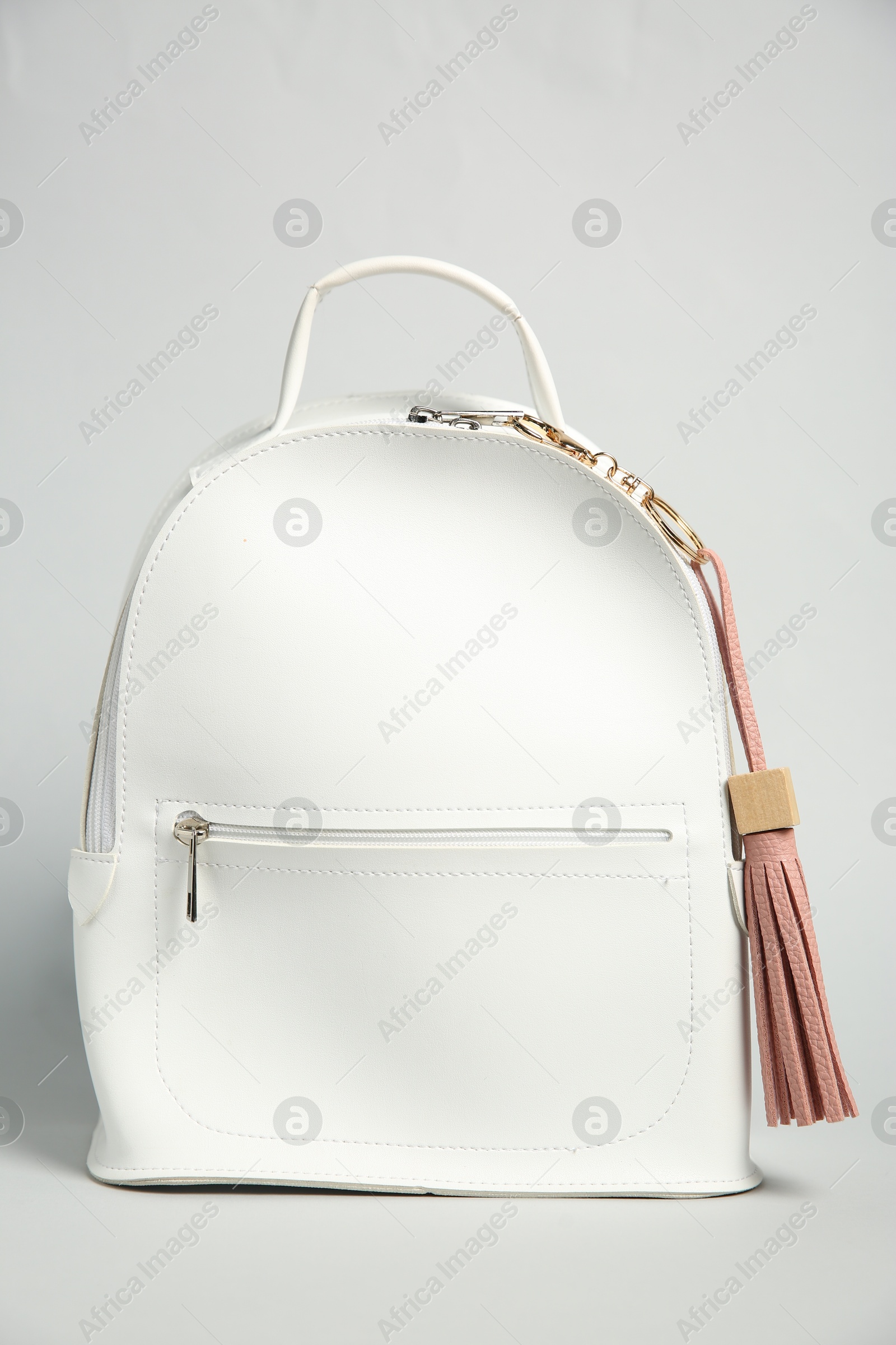 Photo of Backpack with pink leather keychain on grey background