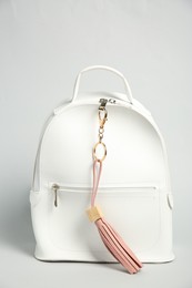 Photo of Backpack with pink leather keychain on grey background