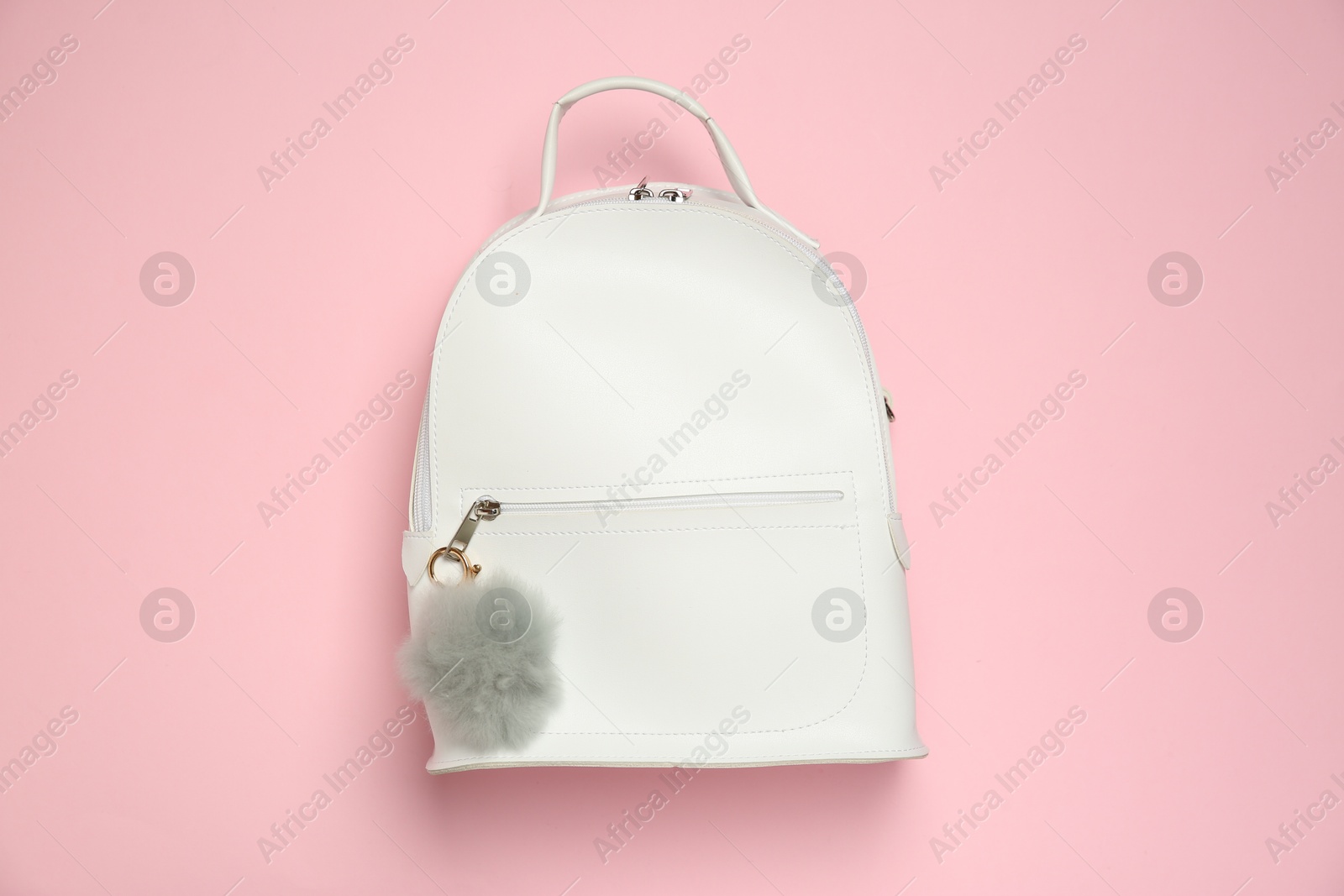 Photo of Backpack with grey faux fur keychain on pink background, top view