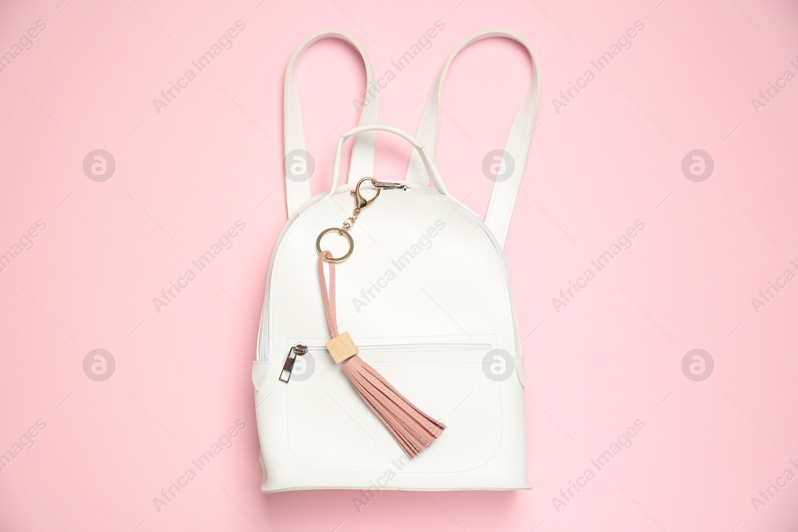 Photo of Backpack with leather keychain on pink background, top view