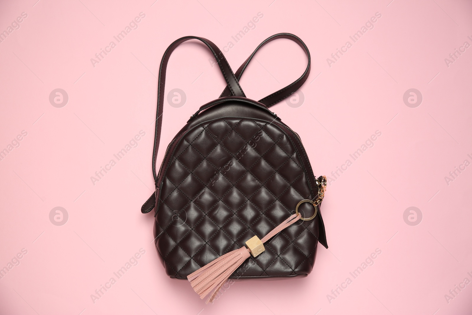 Photo of Backpack with leather keychain on pink background, top view