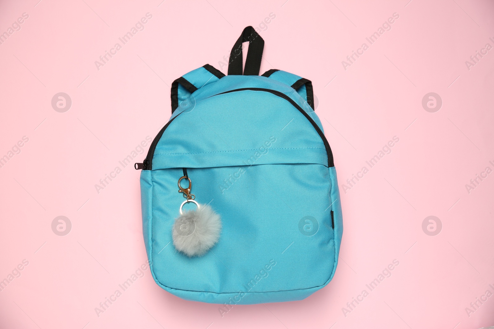 Photo of Backpack with grey faux fur keychain on pink background, top view