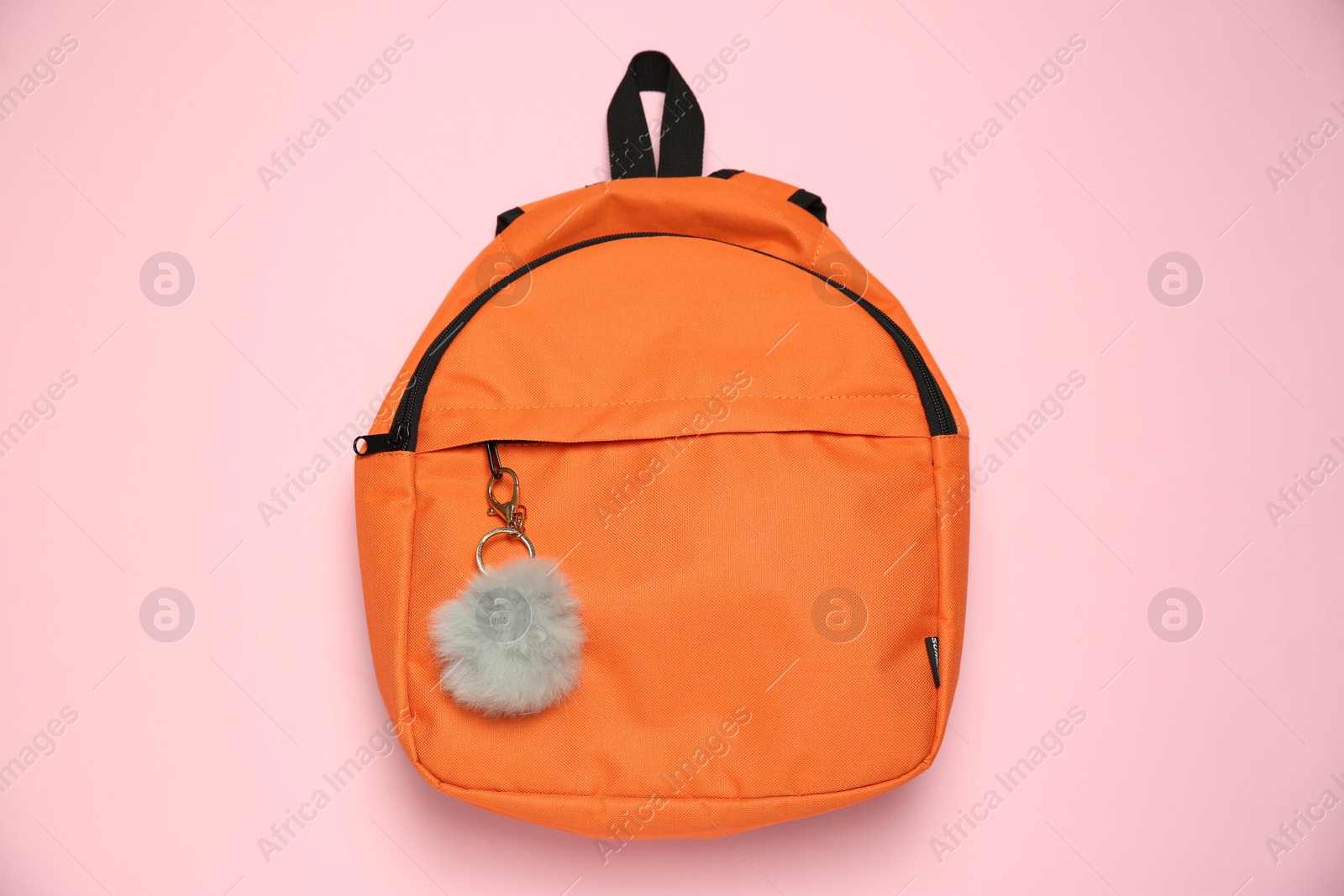 Photo of Backpack with grey faux fur keychain on pink background, top view