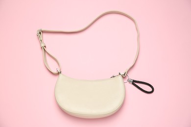 Photo of Bag with black leather keychain on pink background, top view