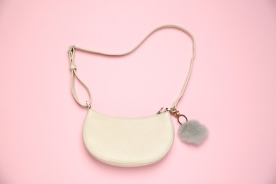 Photo of Bag with grey faux fur keychain on pink background, top view