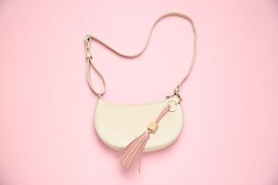 Photo of Bag with leather keychain on pink background, top view