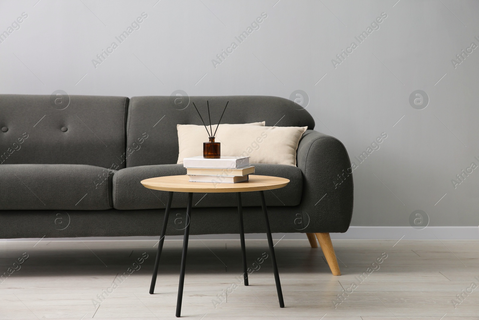 Photo of Comfortable sofa and table near grey wall in room