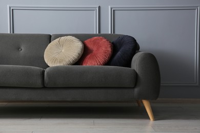 Photo of Stylish sofa with cushions near grey wall