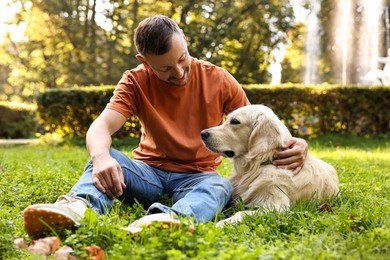 Photo of Man with cute Golden Retriever dog on spring day