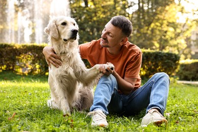 Smiling man with cute Golden Retriever dog on spring day