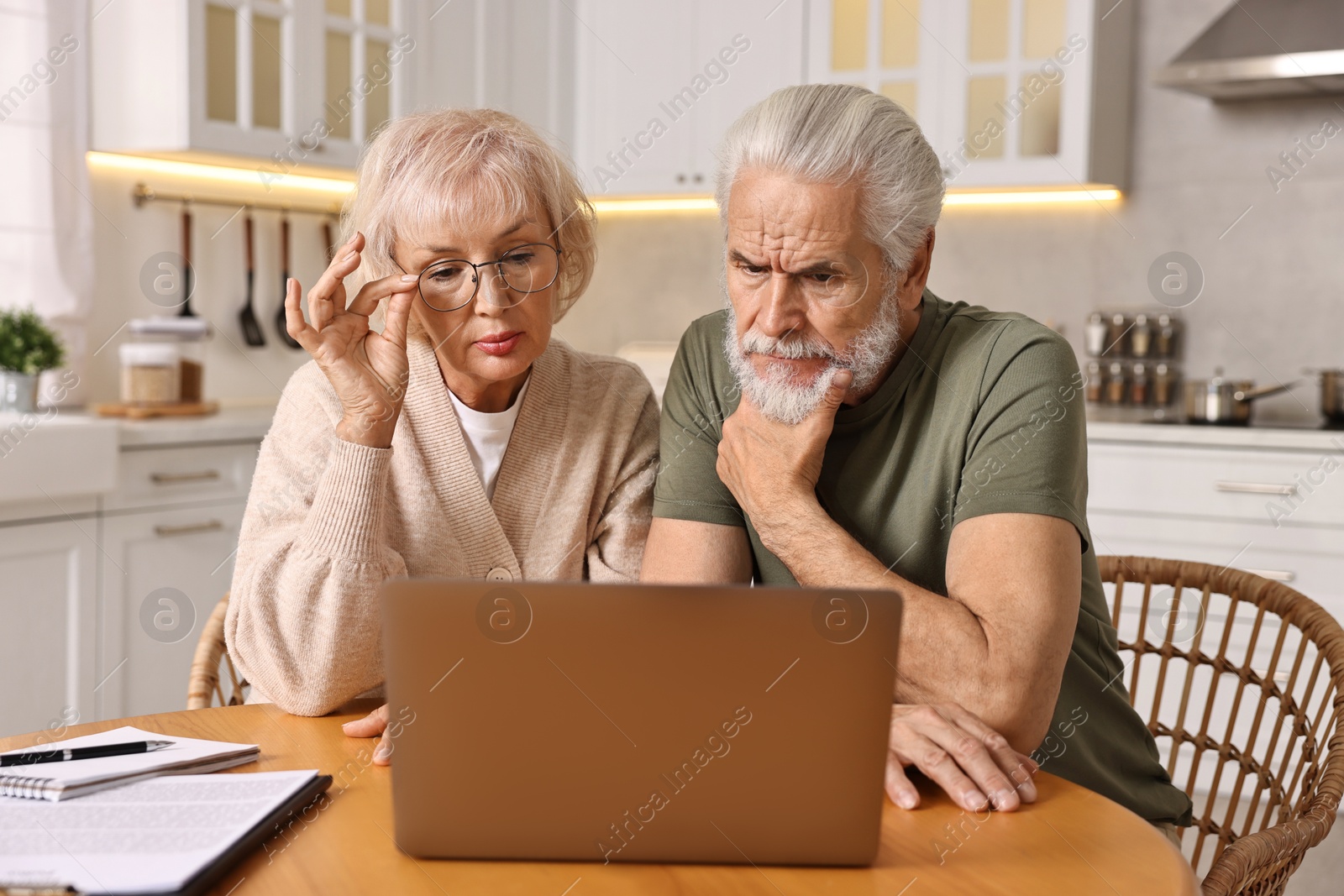 Photo of Pension savings. Senior couple planning budget at wooden table indoors