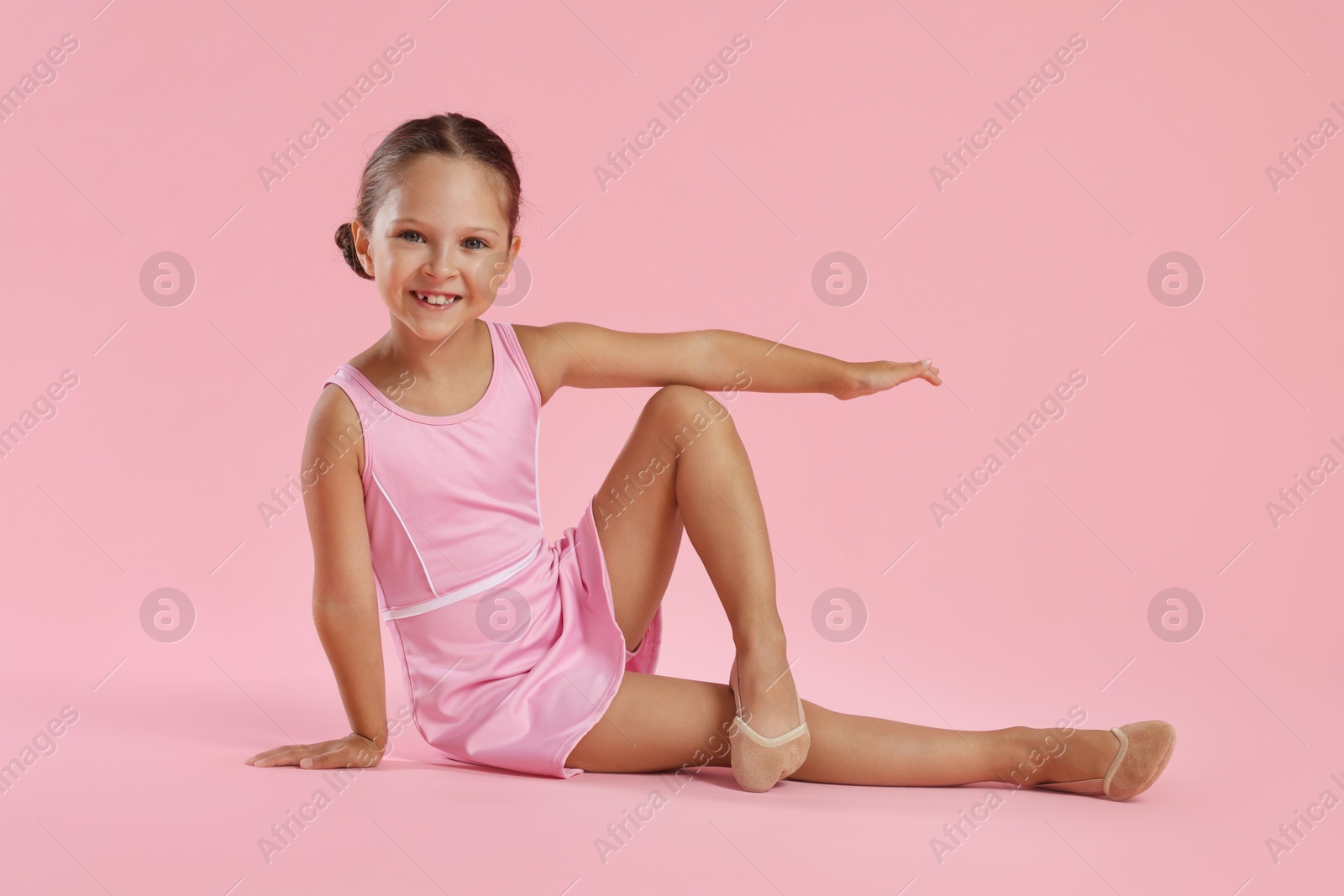 Photo of Portrait of little ballerina on pink background