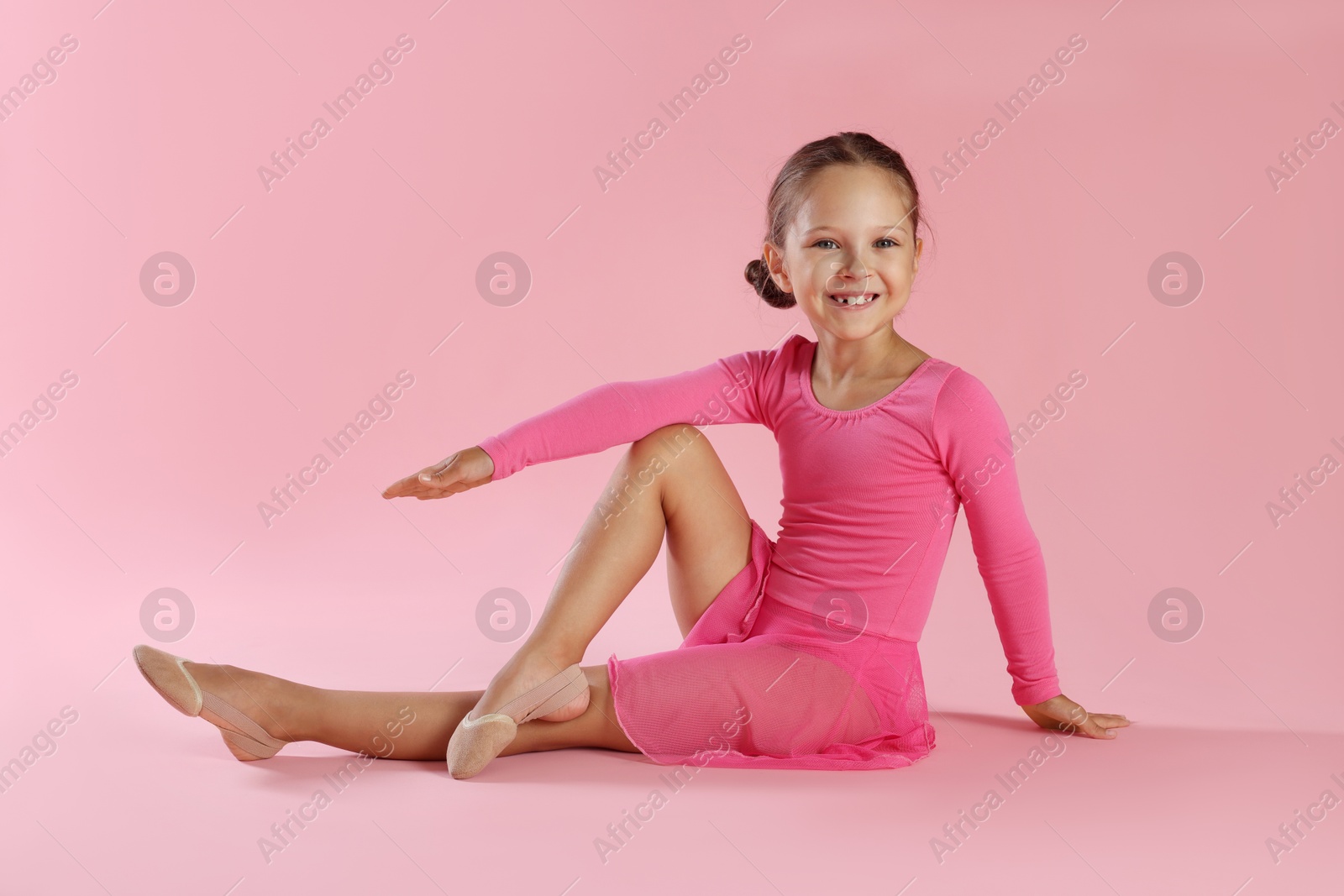 Photo of Portrait of little ballerina on pink background