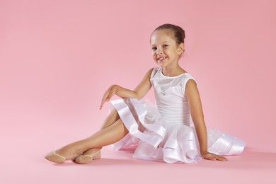 Photo of Portrait of little ballerina on pink background