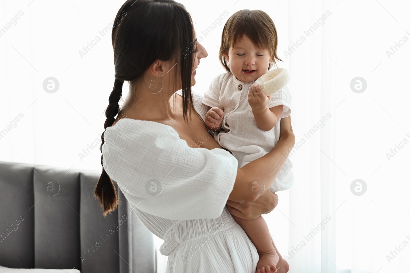 Photo of Beautiful young mother with her cute little baby indoors