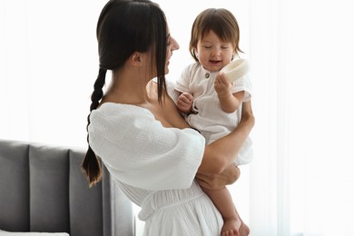 Photo of Beautiful young mother with her cute little baby indoors