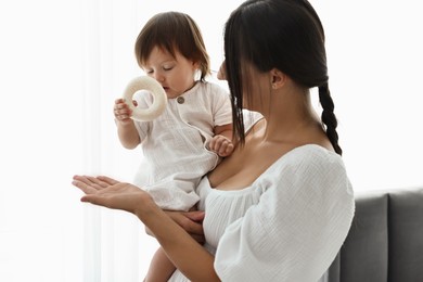 Beautiful young mother with her cute little baby indoors