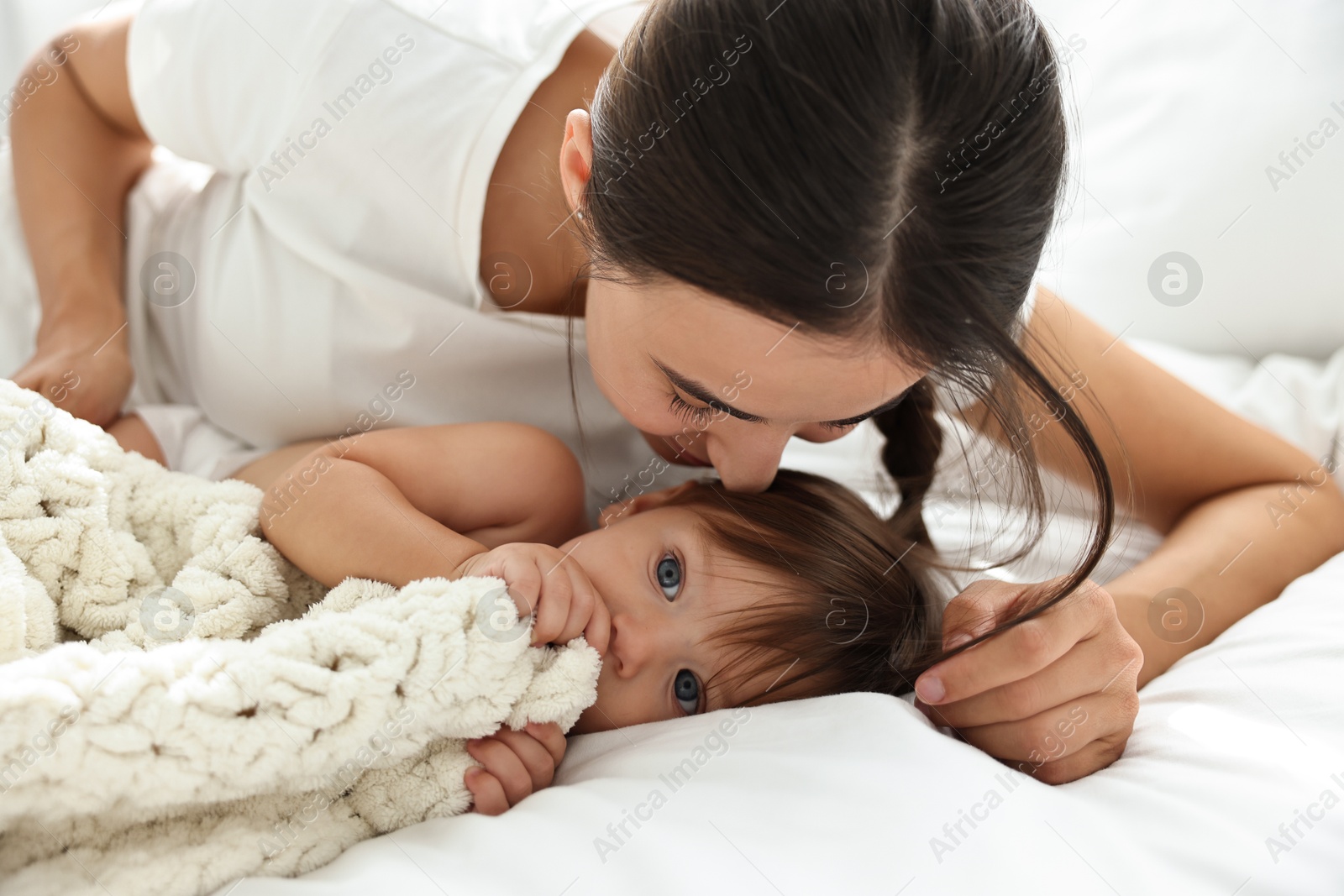 Photo of Beautiful young mother with her cute little baby on bed