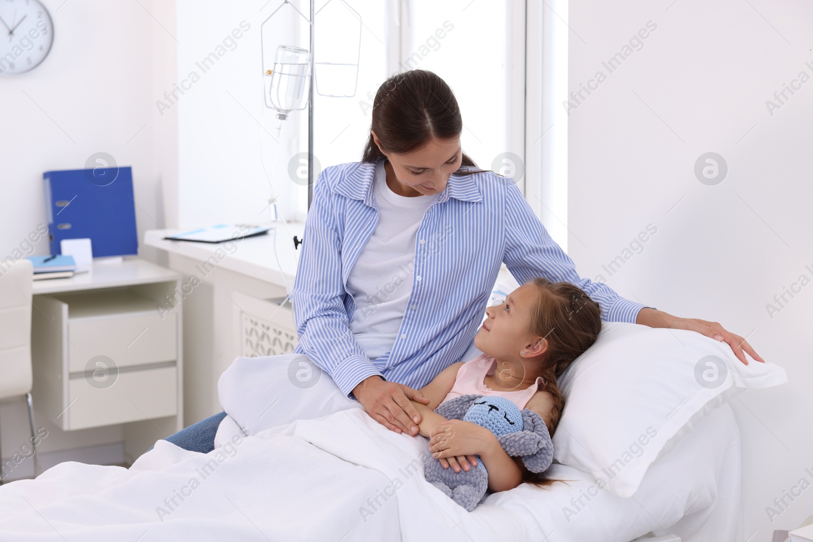 Photo of Mother and her little daughter on bed in hospital