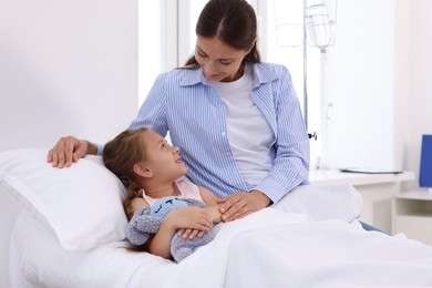 Mother and her little daughter on bed in hospital