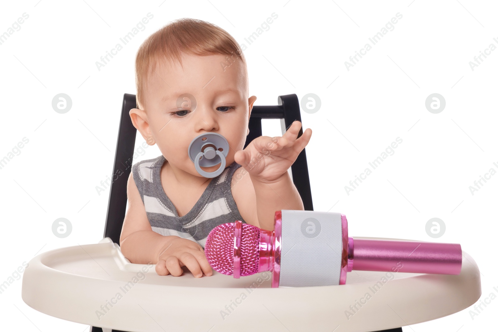 Photo of Cute little baby with pacifier and microphone in high chair on white background