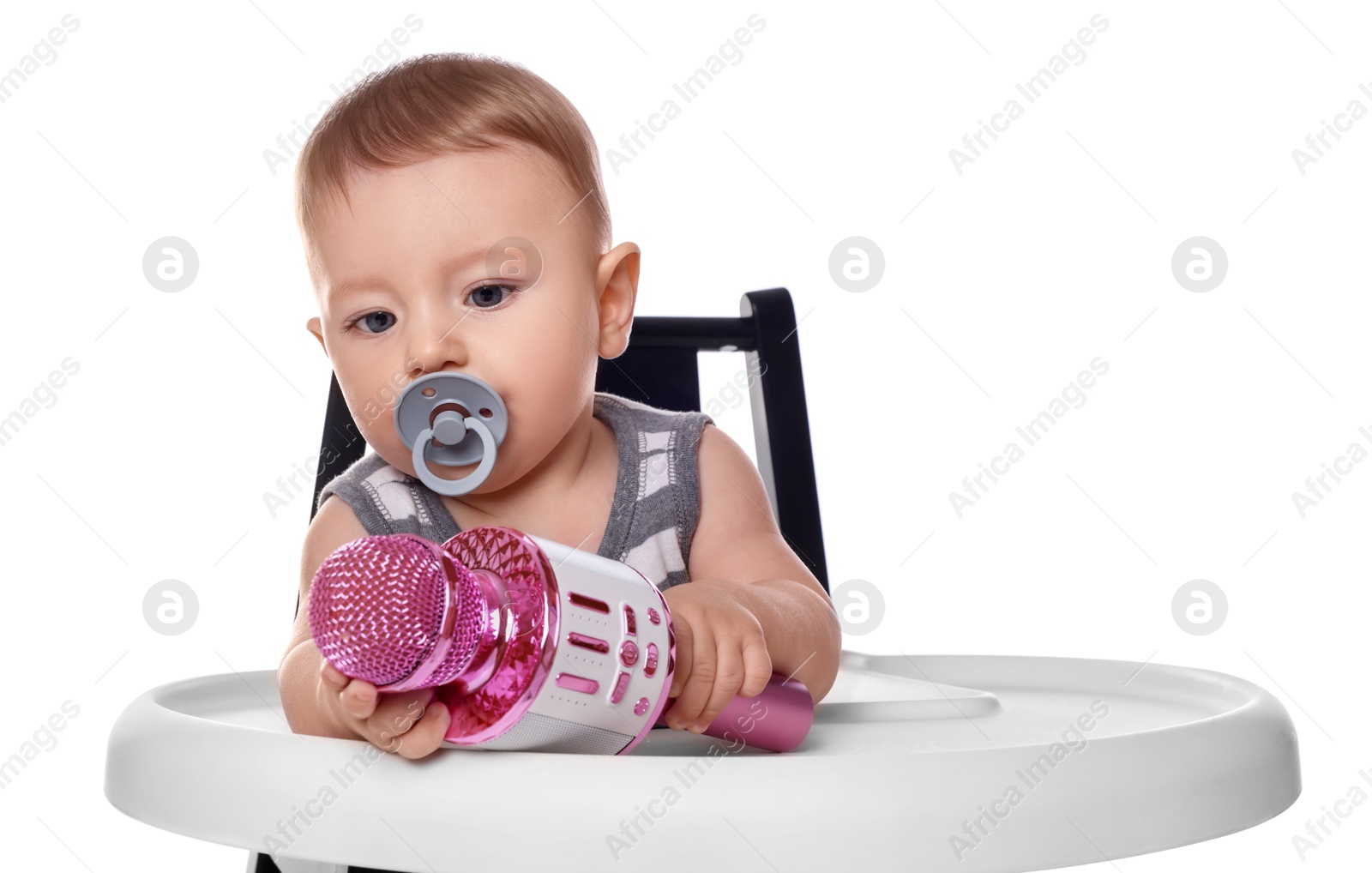 Photo of Cute little baby with pacifier and microphone in high chair on white background