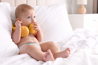 Photo of Cute little baby with headphones on bed at home, space for text