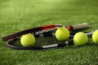 Photo of Tennis rackets and balls on green artificial grass