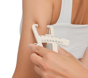 Photo of Nutritionist measuring woman's body fat with caliper on white background, closeup