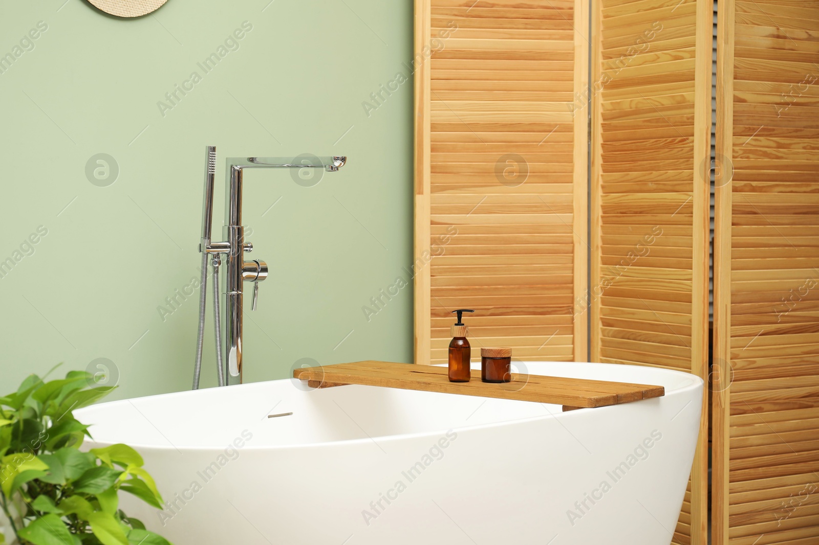 Photo of Folding screen and tub in bathroom. Interior design