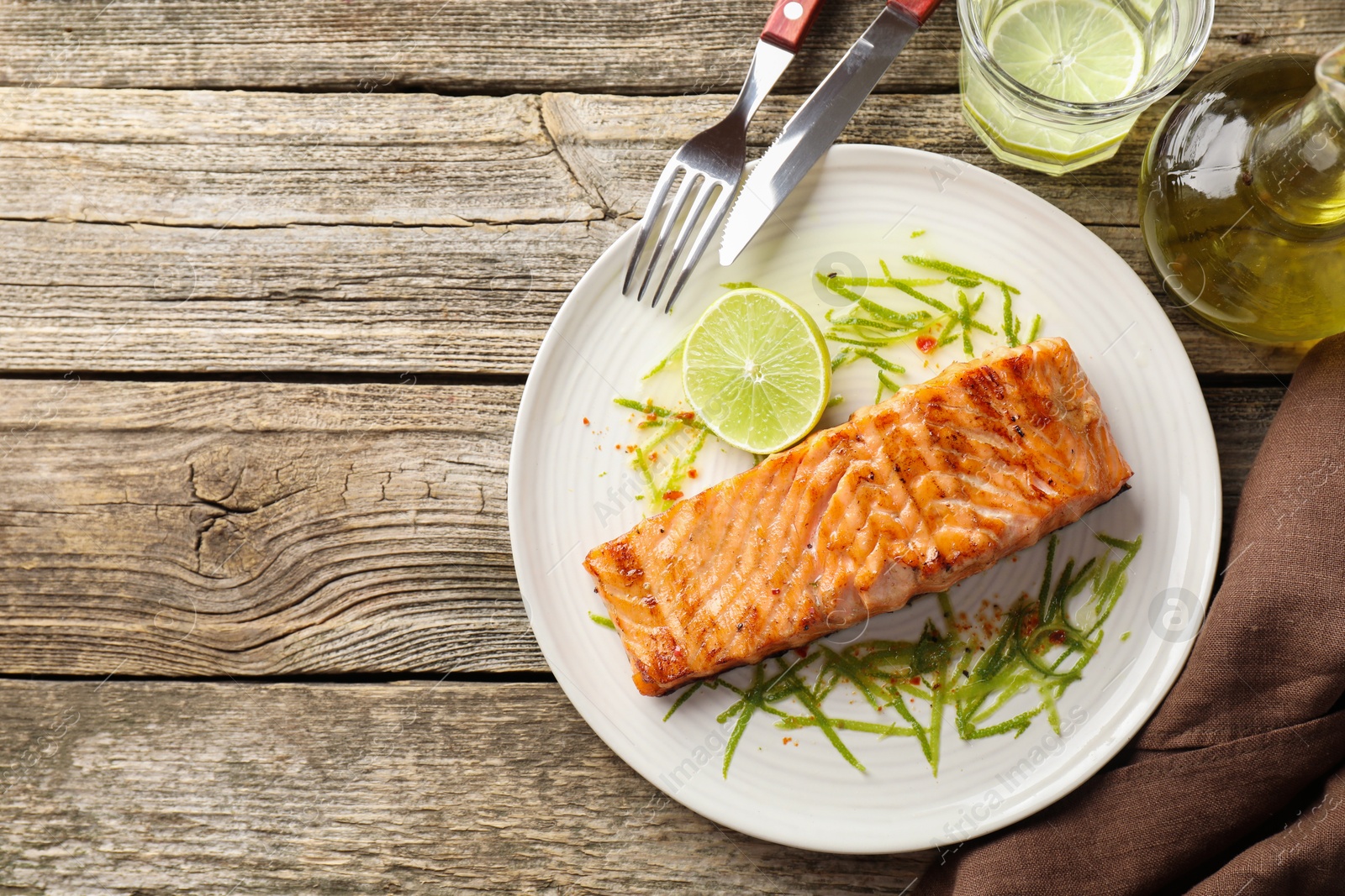 Photo of Delicious grilled salmon fillet served on wooden table, flat lay. Space for text