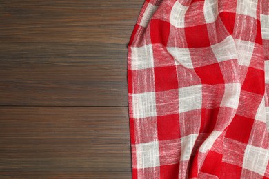 Crumpled tablecloth with checkered pattern on wooden table, top view. Space for text