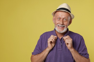 Photo of Portrait of happy senior man on yellow background. Space for text