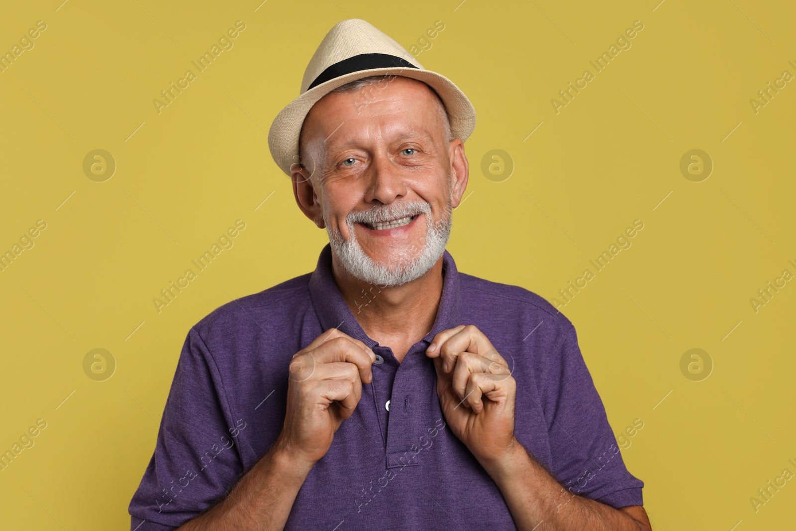 Photo of Portrait of happy senior man on yellow background