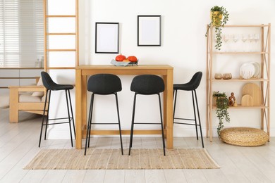 Photo of Bar stools near wooden table in room