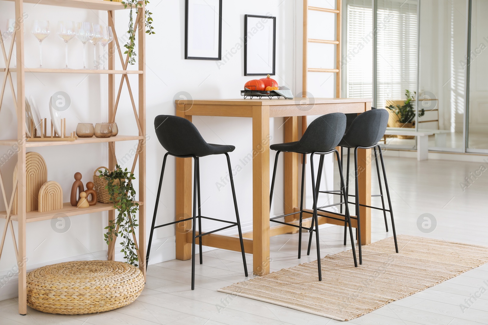 Photo of Bar stools near wooden table in room