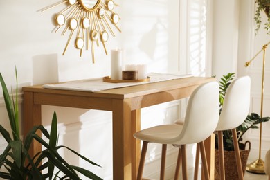 Photo of Bar stools near wooden table in room