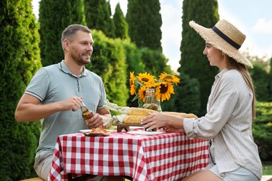 Couple having picnic at table in garden