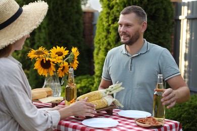 Photo of Couple having picnic at table in garden