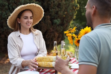 Photo of Couple having picnic at table in garden