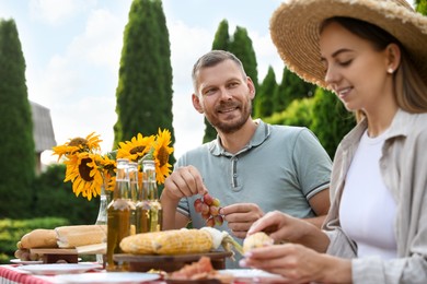 Couple having picnic at table in garden