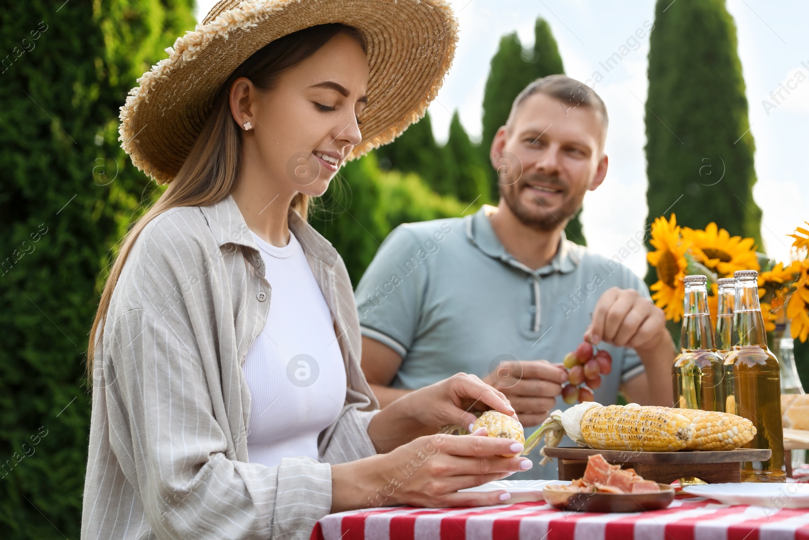 Photo of Couple having picnic at table in garden