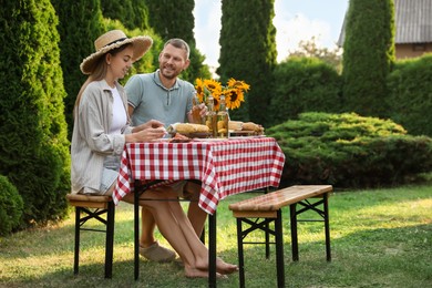 Couple having picnic at table in garden