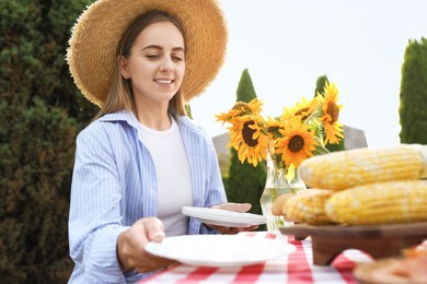 Woman setting table for picnic in garden