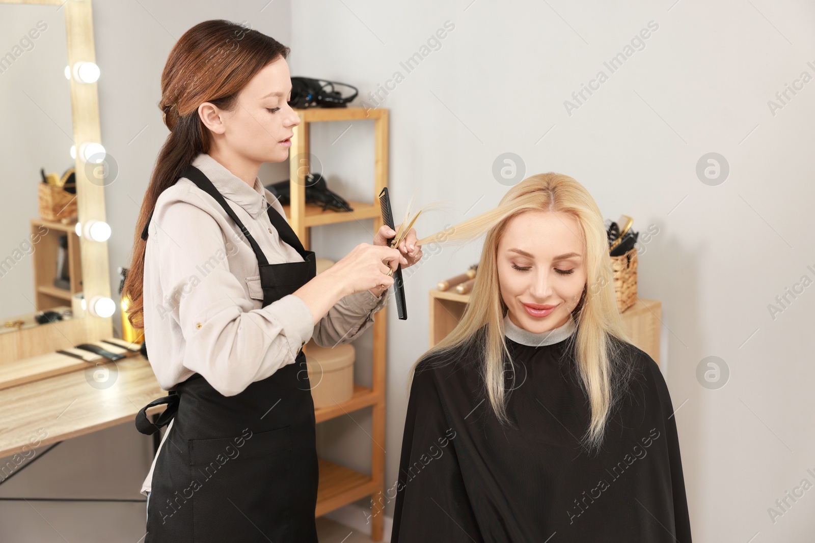 Photo of Hair cutting. Professional hairdresser working with client in salon